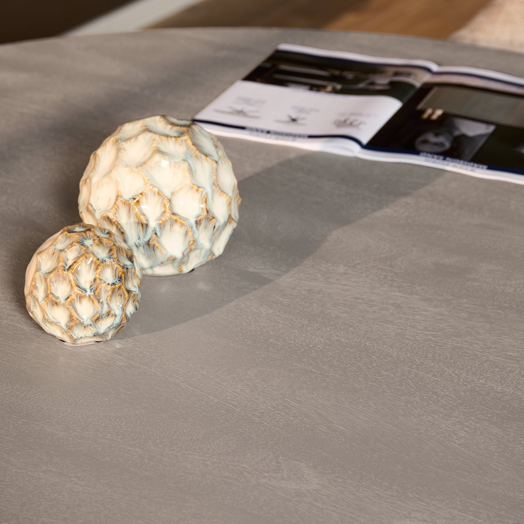 Taupe tafelblad met ronde rand en subtiele nerfstructuur.