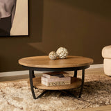 Ronde salontafel met licht mangohouten blad en zwart metalen frame, plank eronder