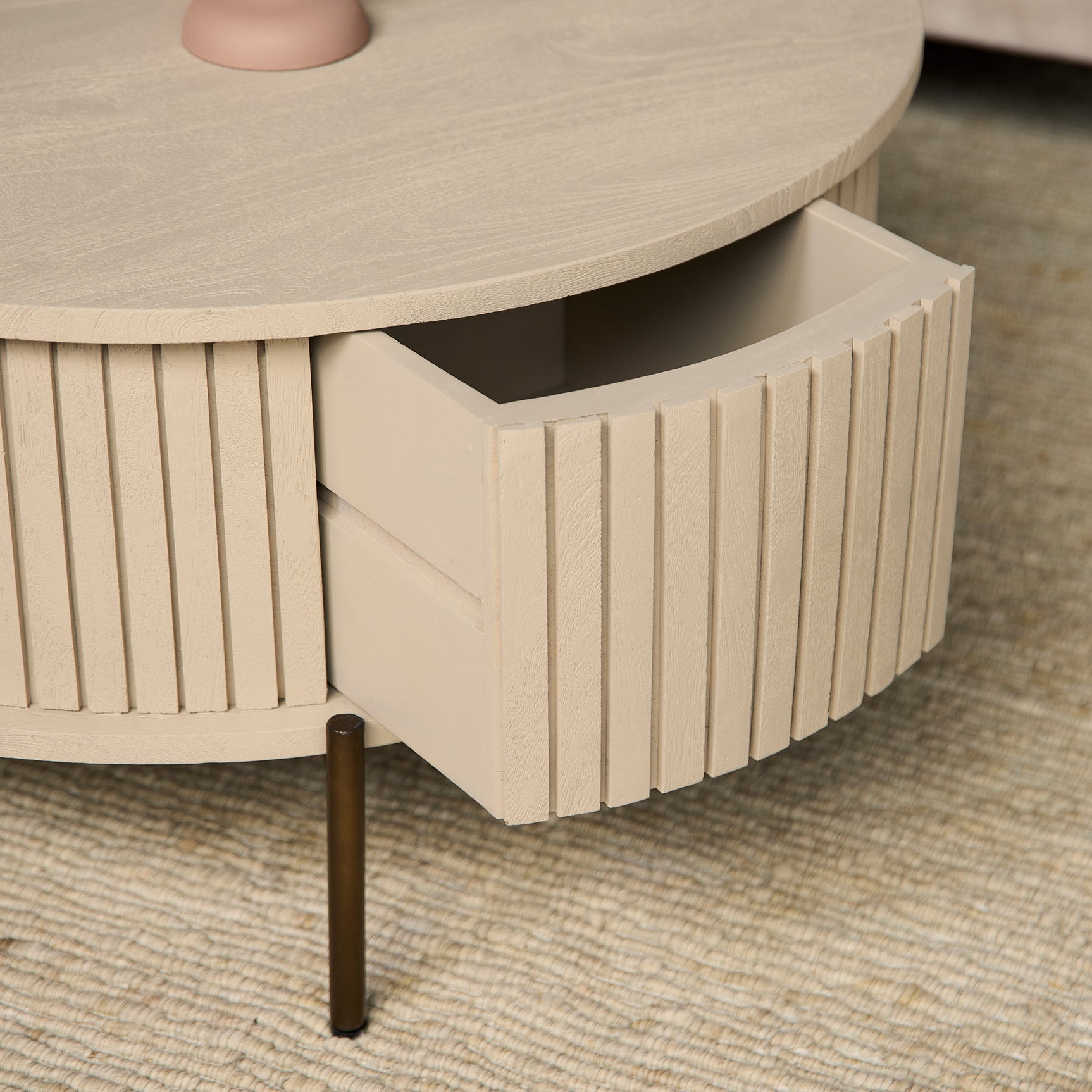Ronde salontafel met open opbergruimte en verticale lamellen, zandkleurige afwerking