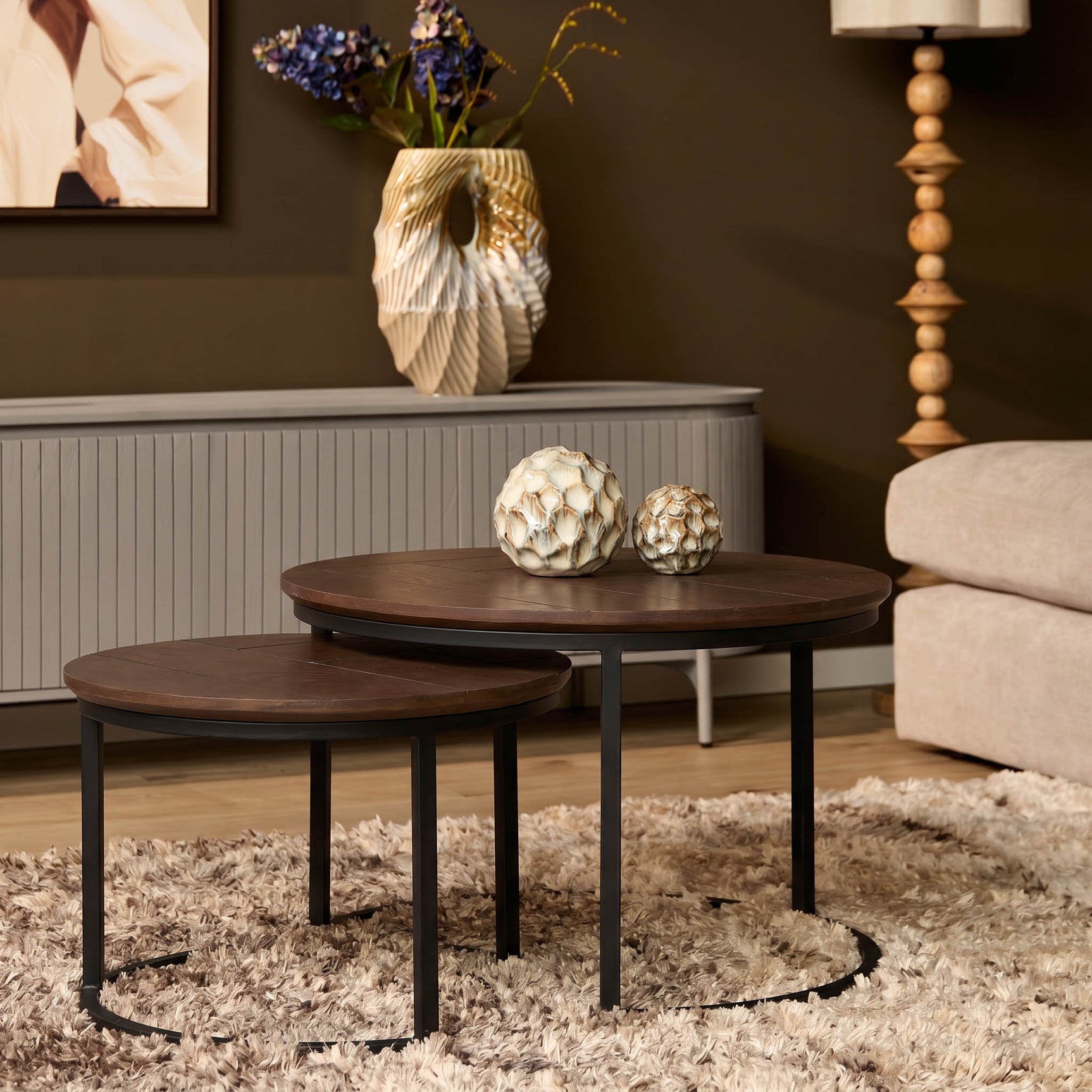 Set van 2 ronde salontafels met donkere houten bladen en zwart metalen onderstel