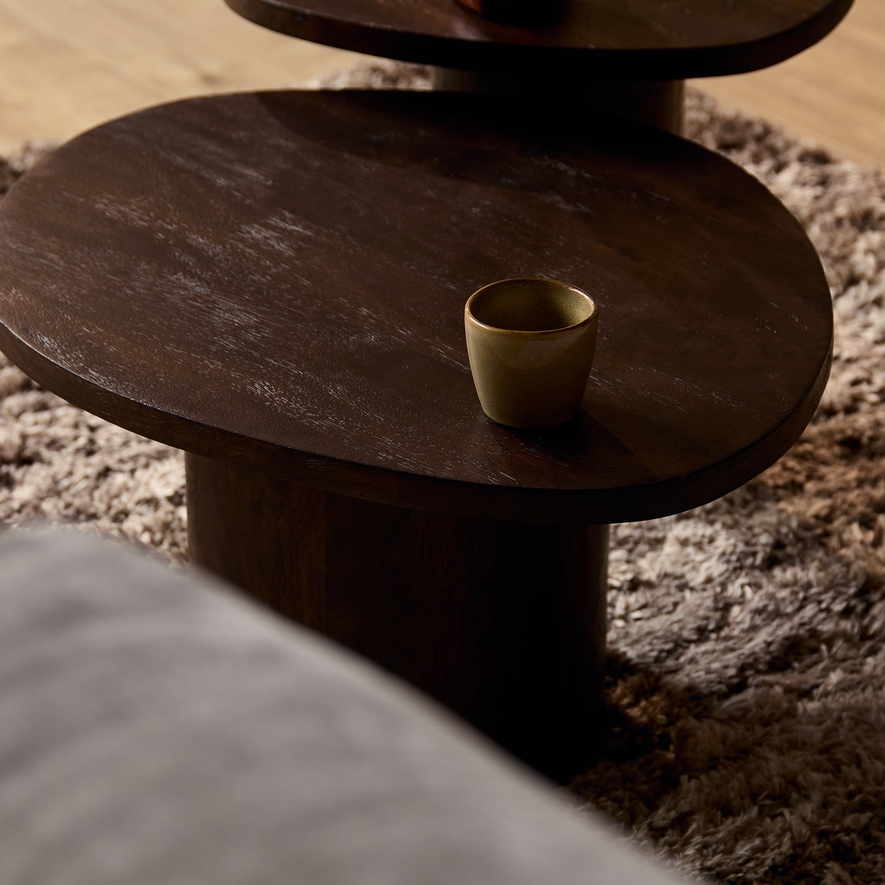 Bruine houten salontafel met afgerond rond blad en dikke poot