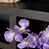 Zwarte vakkenkast met open vak en decoratieve orchidee op schap