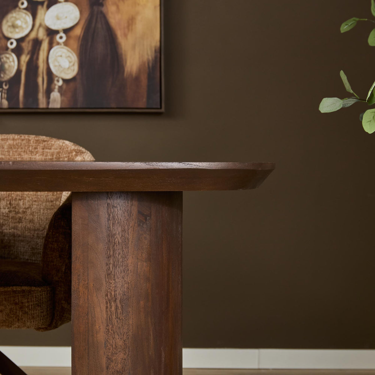 Zijaanzicht van bruine eettafel met houten poot en zichtbare houtnerf