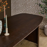 Eettafel van bruin hout met afgerond blad en stevige poot, geschikt voor dagelijks gebruik