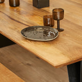Eetkamertafel met eikenhouten blad en zwarte poot, met kaarsen en schaal