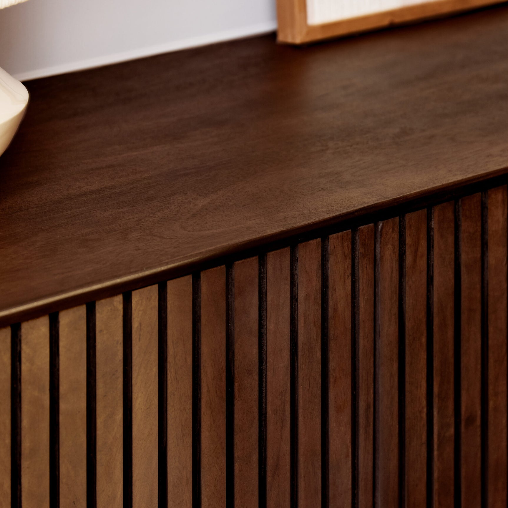 Bruin dressoir met houten blad en verticale ribben op het front