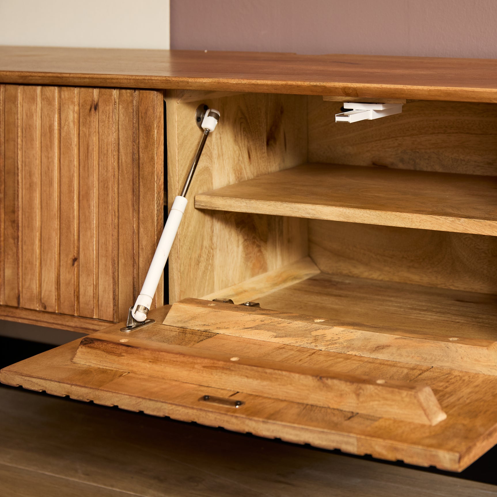 Binnenzijde van naturel tv-meubel met open vak en houten plank