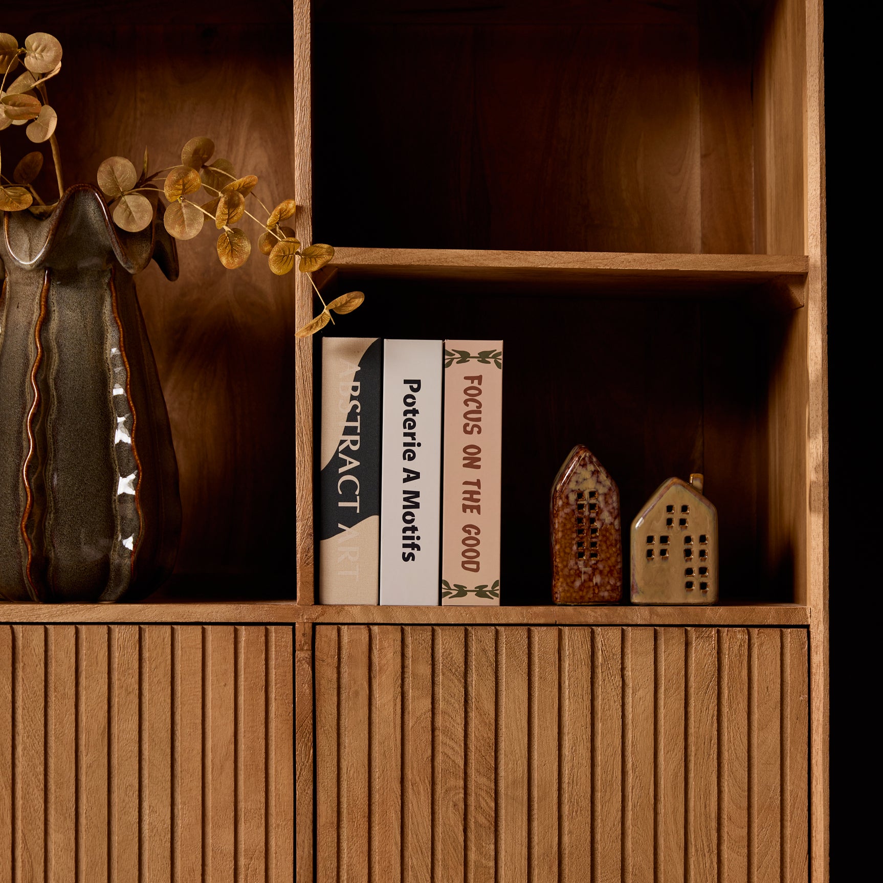 Open vakkenkast met naturel houten planken en opbergvak met accessoires.