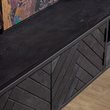 Zwevend tv-meubel: herringbone paneel en donkere frontbalk met decoratieve ruitvormige lijnen.