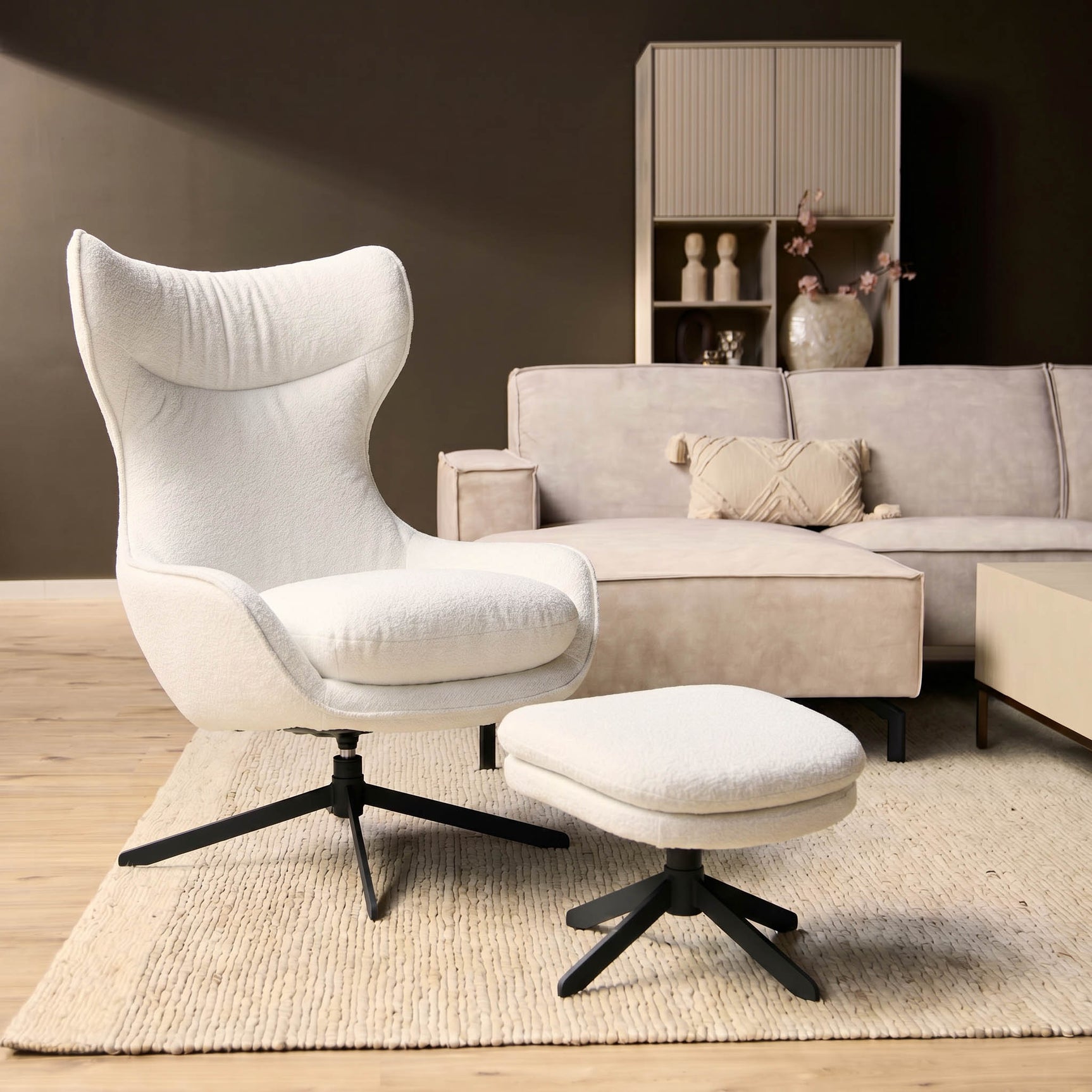 Fauteuil Olivia in gebroken wit met poef en zwarte draaivoet