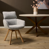 Eetkamerstoel Jona in taupe stof, ronde rug en armleuningen, houten pootjes.