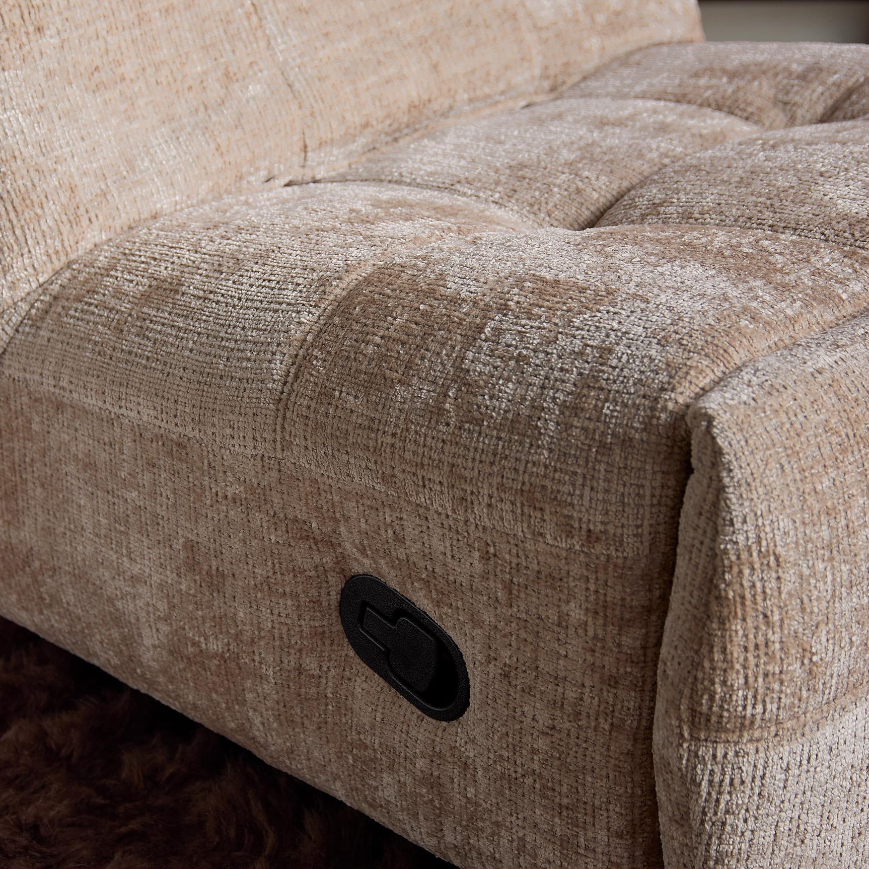 Beige relaxfauteuil zijpaneel met zwarte bedieningsknop en grove stof