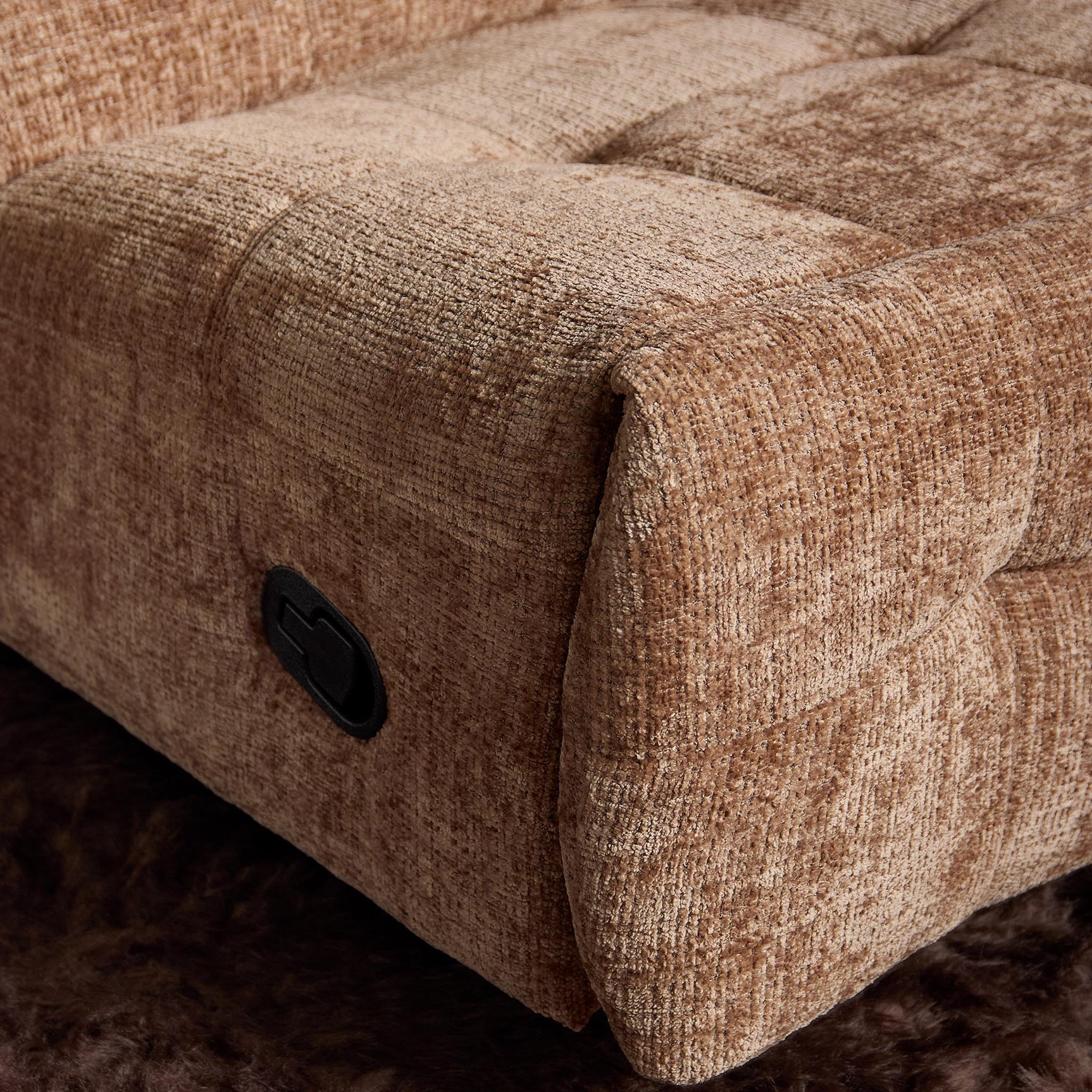 Kaneel relaxfauteuil in beige stof, close-up van armleuning en zwarte bedieningsknop