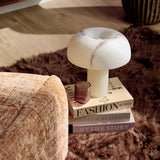Kaneel relaxfauteuil in beige stof, voetensteun in focus met afgeronde zijkant