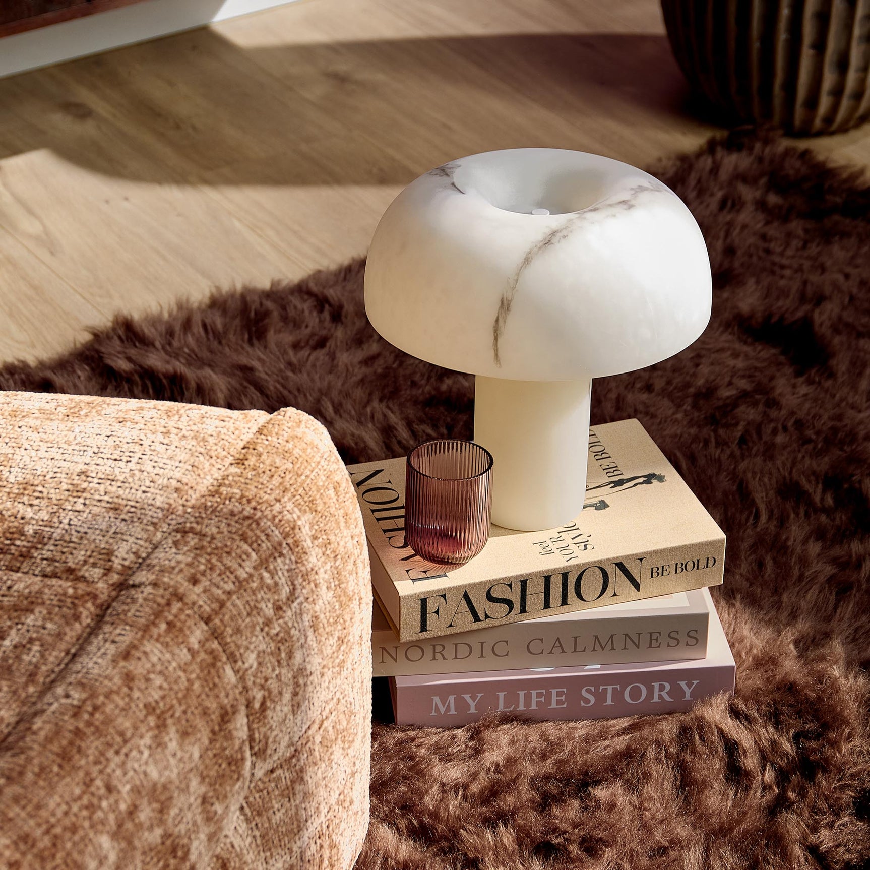 Kaneel relaxfauteuil in beige stof, voetensteun in focus met afgeronde zijkant