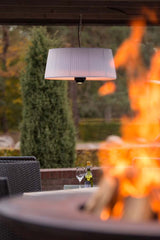 Hangende witte terrasverwarmer met oranje warmtegloed onder de lampenkap
