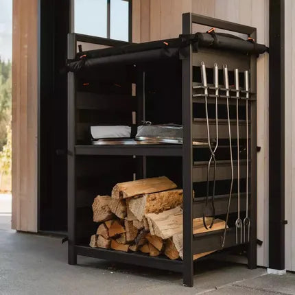 Zwarte Solo Stove opbergkast met open rek en stapel houtblokken