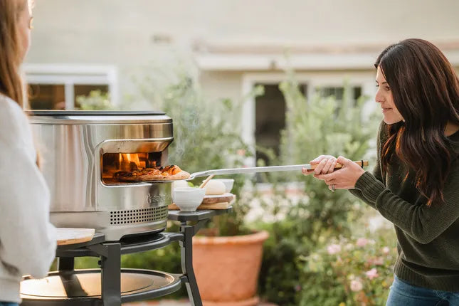 RVS pizzadraaier met houten handgreep en pizza op de geperforeerde schep