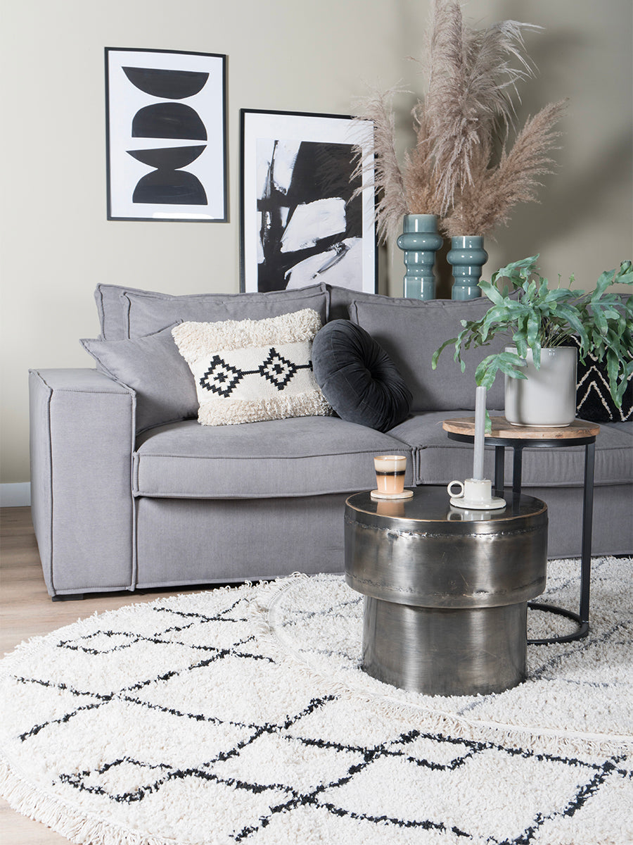 Rond vloerkleed met crèmekleurige basis en zwart ruitvormig mozaïekpatroon